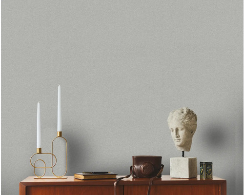 Dekoratives Interieur mit Tapete, Kerzenhalter, Büste und Vintage Kamera auf einer Kommode