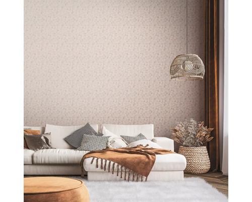 Wohnzimmer mit Couch, Kissen, Decke, Lampe und floral gemusterter Tapete