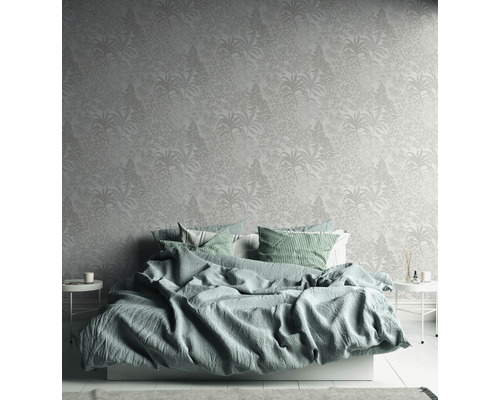 Schlafzimmer mit floral gemusterter Tapete und Bett