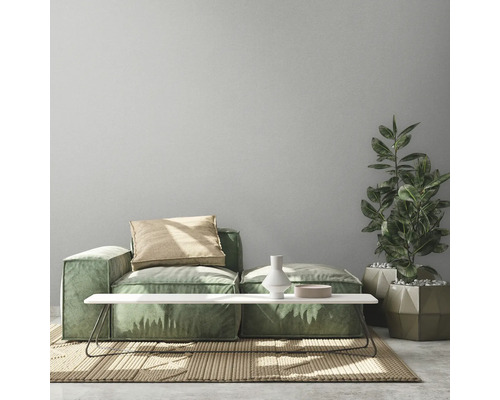 Helle Inneneinrichtung mit grünem Modulsofa, Couchtisch, Zimmerpflanze und Teppich