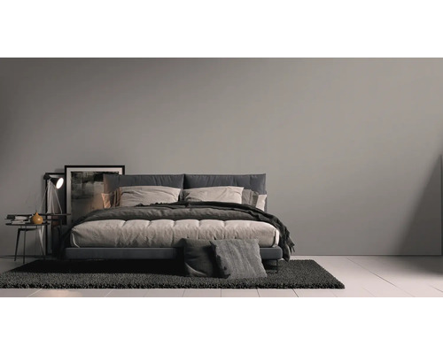 Schlafzimmer mit Bett, Nachttisch, Lampe und Teppich