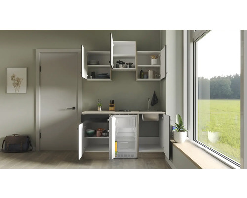 Kompakte Küchenzeile mit Spüle, Kochfeld und Kühlschrank in einem hellen Raum.