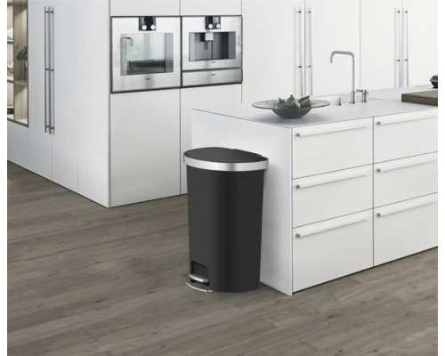 Schwarzer Treteimer in einer modernen Küche mit weißen Schränken