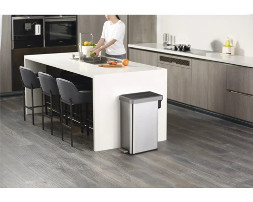 Moderne Küche mit Edelstahl-Treteimer, Kücheninsel und Barhockern.