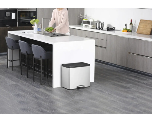 Moderne Küche mit Kücheninsel, Barhockern und einem silberfarbenen Treteimer.