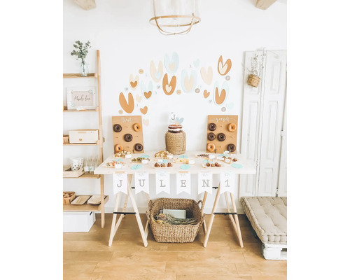 Dekorierter Geburtstagstisch mit Donuts, Kuchen und Snacks für eine Feier