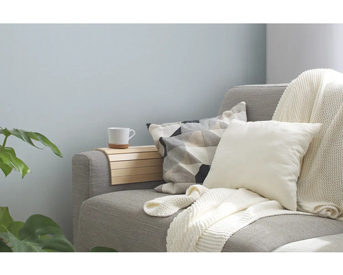 Graues Sofa mit Kissen, Decke und Ablage