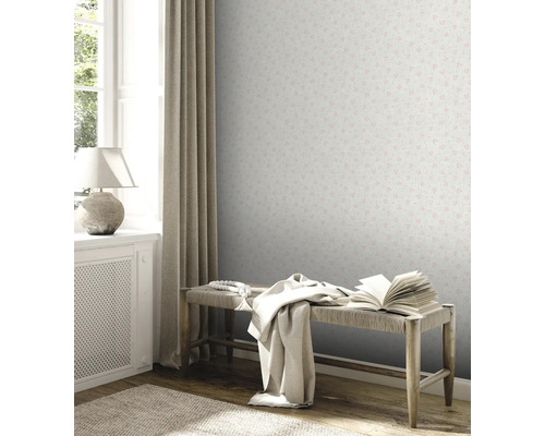 Dekoratives Zimmer mit gemusterter Tapete, Bank und Textilien.