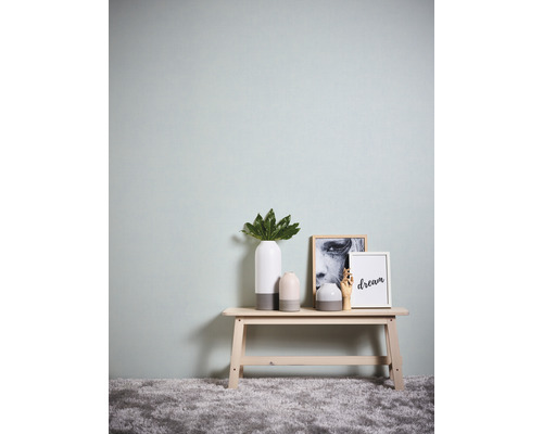 Dekorative Szene mit Vase, Pflanze und Bilderrahmen auf einem Tisch