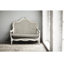 Vintage Sofa mit Stoffbezug vor einer Wand