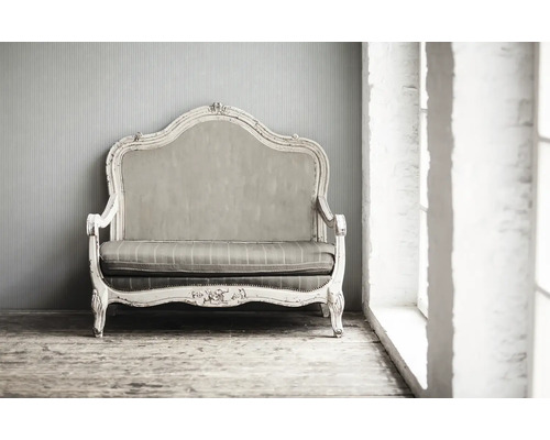 Vintage Sofa mit Stoffbezug vor einer Wand