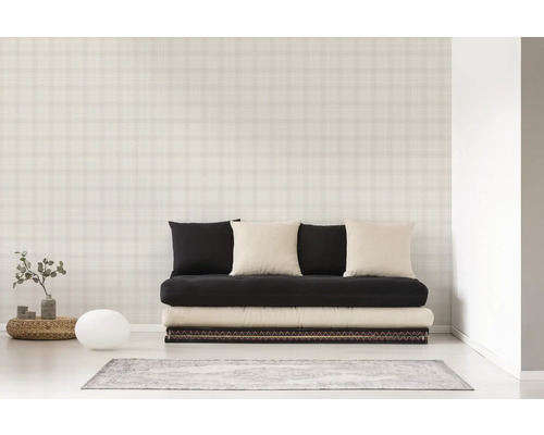 Ein Zimmer mit einer Couch, Kissen und einer Tapete mit Karomuster.