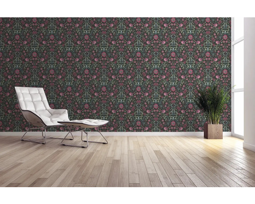 Wohnraum mit floral gemusterter Tapete, Sessel und Zimmerpflanze.