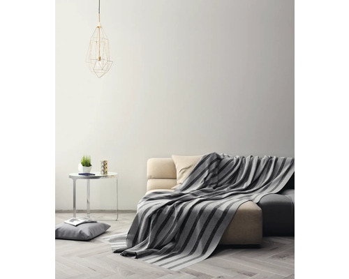 Wohnzimmer mit Sofa, Decke, Beistelltisch und Lampe