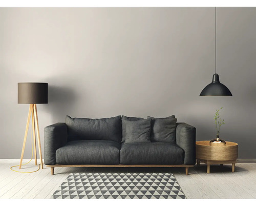 Wohnzimmer mit grauem Sofa, Stehlampe, Pendelleuchte und gemustertem Teppich