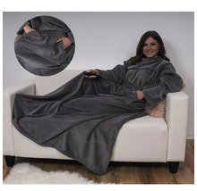 Frau mit Ärmeldecke auf Sofa mit Tasche