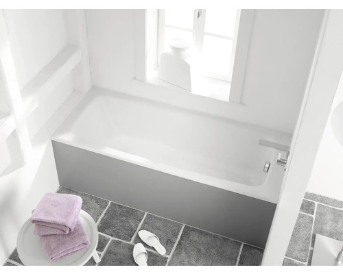 Badezimmer mit Badewanne, Handtüchern und Badeschuhen auf grauem Fliesenboden
