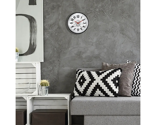 Wohnzimmer mit Wanduhr, Sofa und dekorativen Elementen