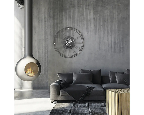 Wohnzimmer mit Kaminofen, Wanduhr, Sofa und Teppich