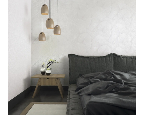 Schlafzimmer mit Bett, Nachttisch, Lampe und gemusterter Tapete