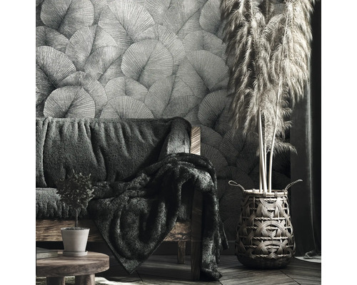 Wohnzimmer mit gemusterter Tapete, Sofa und dekorativem Gras in einem Korb