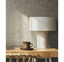 Szene mit Schreibtisch, Tischlampe, Tasse und Notizbüchern vor einer strukturierten Wand