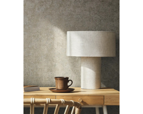 Szene mit Schreibtisch, Tischlampe, Tasse und Notizbüchern vor einer strukturierten Wand