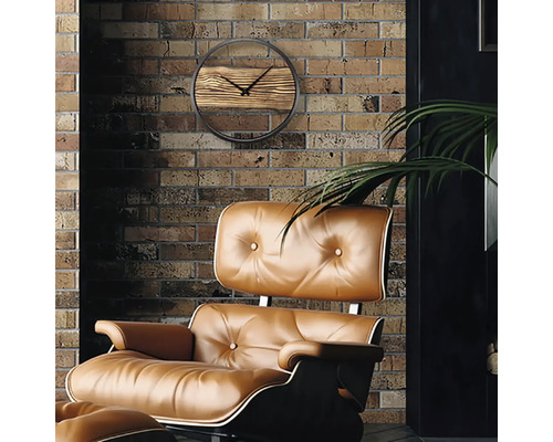 Wohnszene mit einer Wanduhr mit Holzdetails und einem Sessel mit Polsterung vor einer Backsteinmauer.