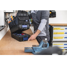 Geöffnete Werkzeugtasche mit Werkzeugen auf einer Werkbank