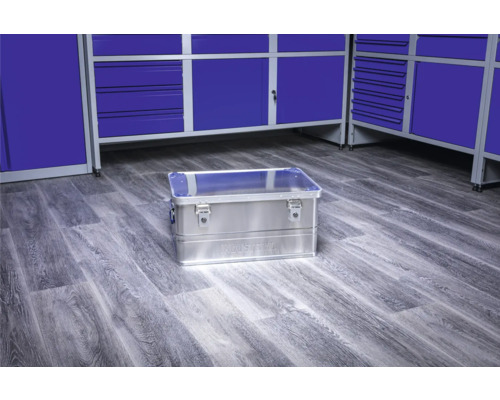 Aluminium Werkzeugkiste auf einem Werkstattboden vor blauen Werkzeugschränken
