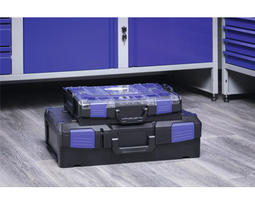 Zwei gestapelte Werkzeugkoffer aus Kunststoff vor einem Werkstattschrank