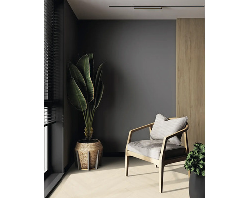 Wohnzimmer mit Sessel, Zimmerpflanze und minimalistischer Einrichtung