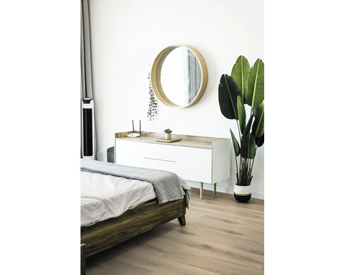 Schlafzimmer mit Bett, Kommode, Spiegel und Pflanze