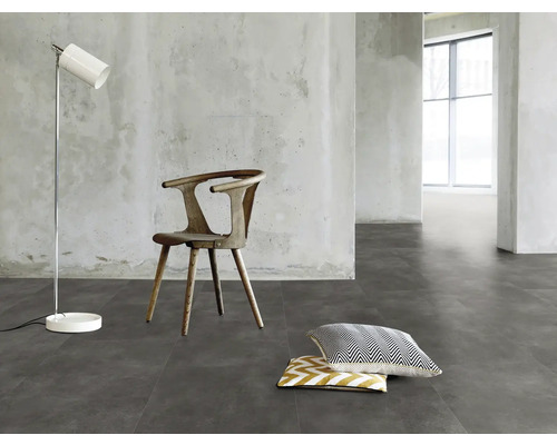 Innenraum mit Stuhl, Stehlampe und Kissen auf grauem Boden