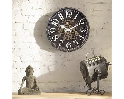 Dekorative Szene mit einer Wanduhr mit Zahnradmuster, einer Buddha Statue und einer Scheinwerferlampe.