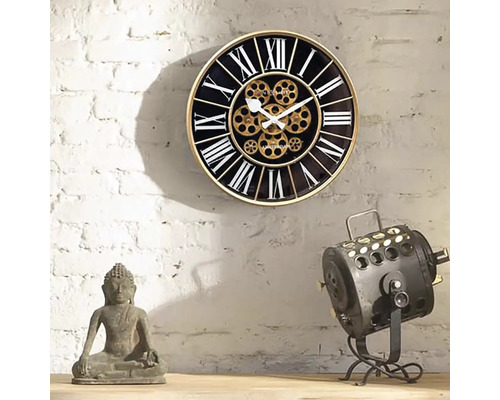 Dekorative Wanduhr mit römischen Ziffern und sichtbarem Uhrwerk neben einer Buddha-Statue und einer Lampe