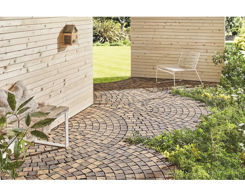 Außenbereich mit Pflastersteinen, Sitzgelegenheit und Holzwand