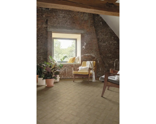 Dachgeschosszimmer mit Holzbalken, Ziegelwand, Fenster und Holzboden in Fischgrätmuster, dekoriert mit Zimmerpflanzen und Sesseln