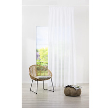 Helles Zimmer mit weißem Vorhang, Rattansessel und Pouf mit Zeitschrift