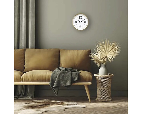 Wohnzimmer mit Sofa, Holztisch, Wanduhr und Dekorationen.