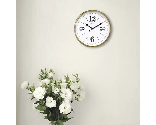 Wanduhr mit rundem, goldenem Rahmen und Blumenstrauß