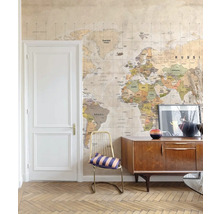 Wohnraum mit Weltkarten-Tapete, Kommode und Stuhl