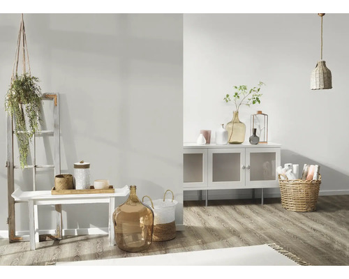 Helles Wohnzimmer mit weißem Sideboard, Dekoration und geflochtenem Korb