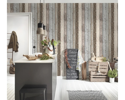 Heller Raum mit Kücheninsel, Holzkisten und Wandtapete in Holzoptik