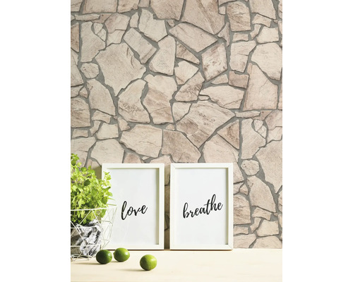 Wand mit Steinmuster und zwei Bilderrahmen mit den Aufschriften Liebe und Atmen.
