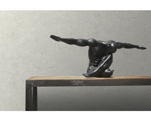 Dekorative Skulptur einer sitzenden, muskulösen Figur auf einem Holztisch