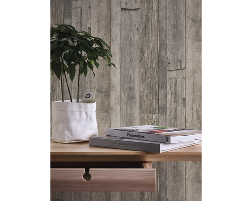 Dekorative Wand mit Holzpaneel-Tapete, Pflanze und Büchern auf einem Tisch