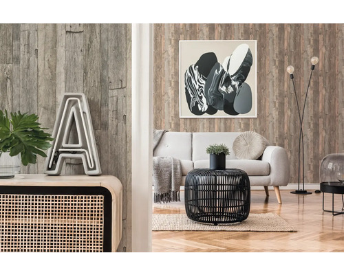 Wohnzimmer mit Holzwandtapete, Sofa und dekorativen Elementen wie Tisch, Lampe und Bild