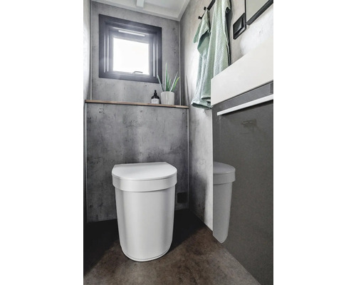 Modernes Badezimmer mit Toilette, Waschbecken und Fenster für eine helle und organisierte Atmosphäre