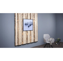 Wanddekoration aus Holz mit Bergmotiv in einem Rahmen, neben einem Sessel und einer Zimmerpflanze.